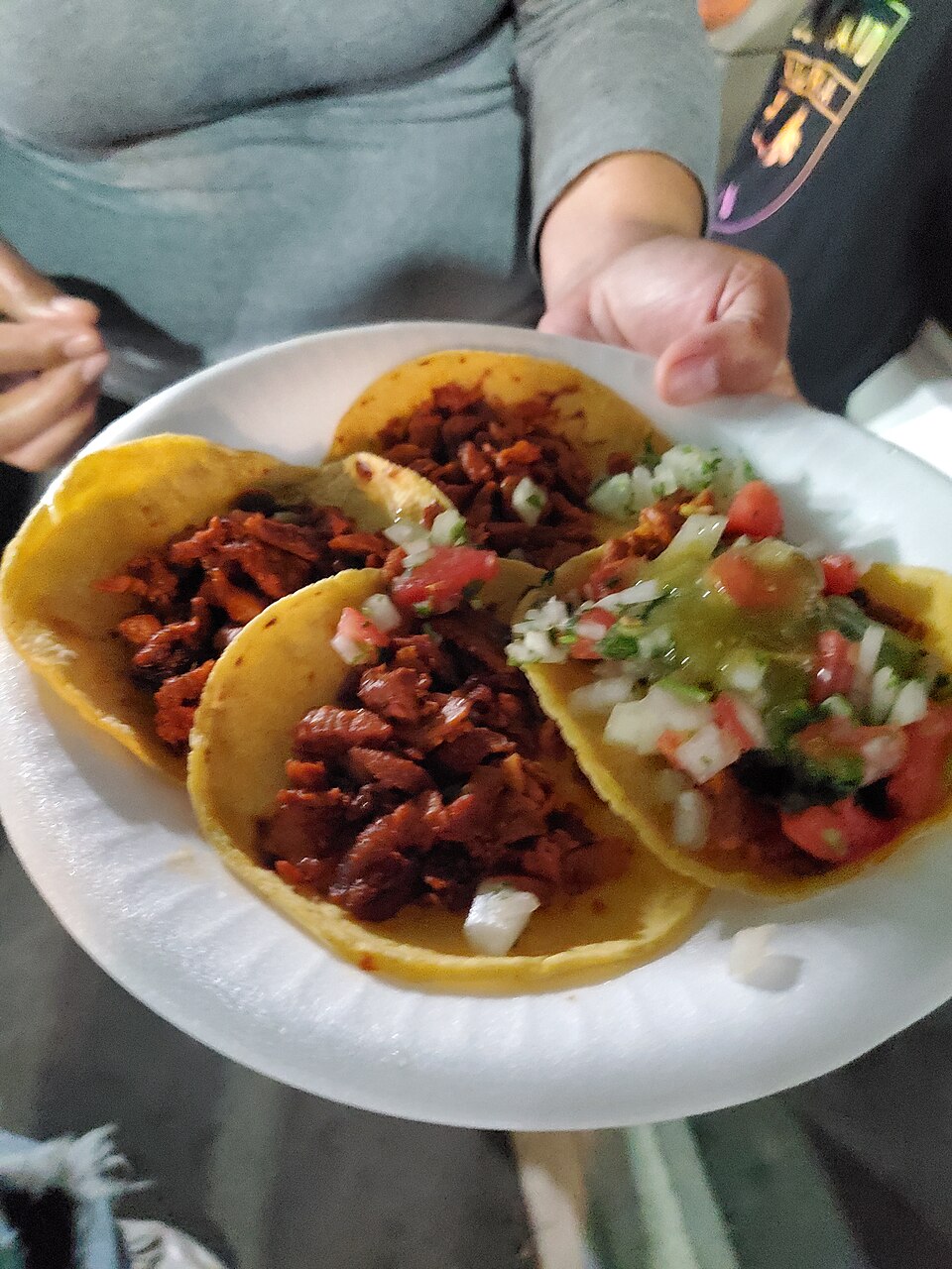 Illustrative birria tacos on a plate; this Wikimedia Commons photograph is not Taco-Bout-Joy's food or premises.